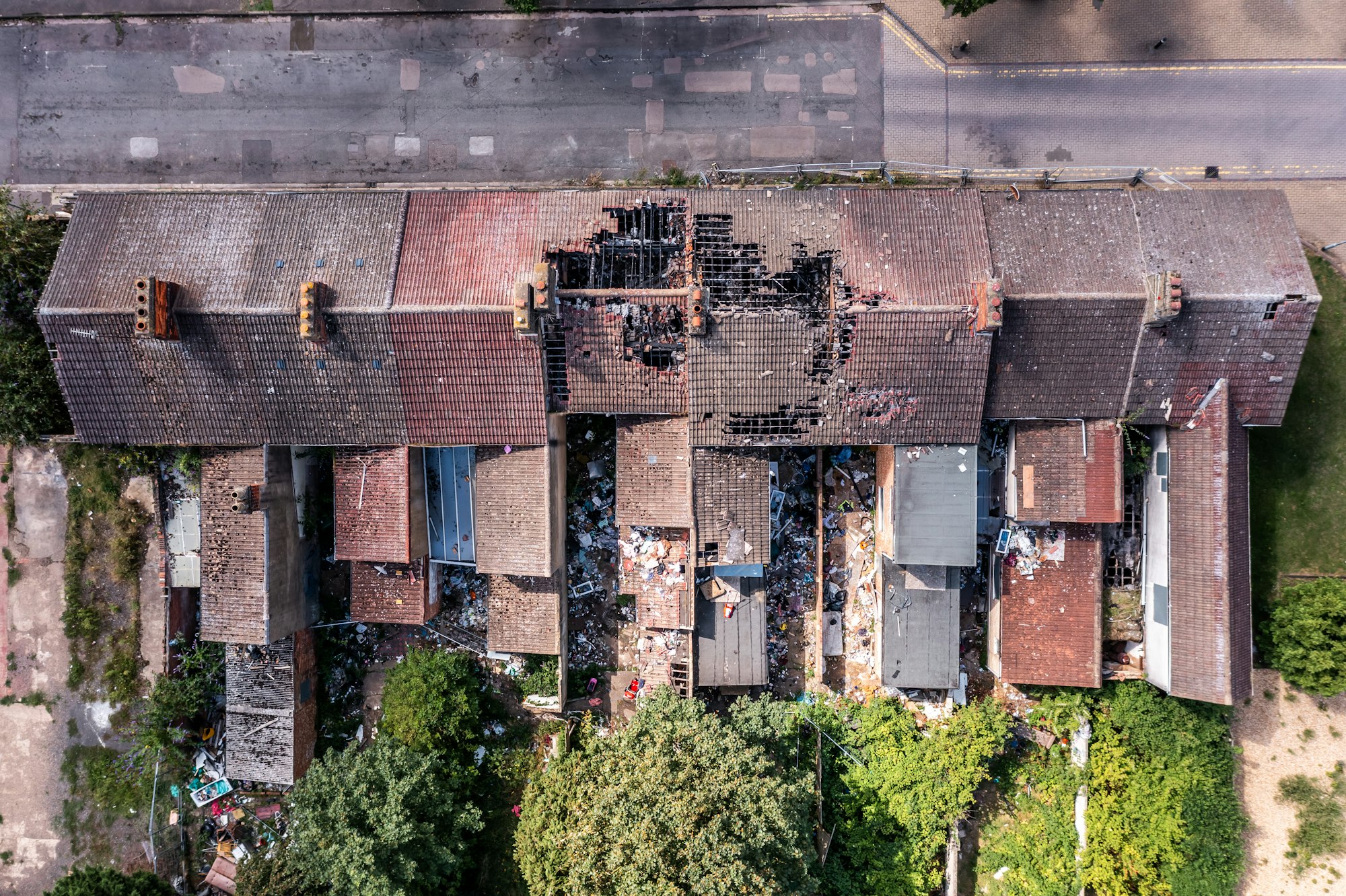 Aerial view directly above the roof of derelict terraced houses after a house fire