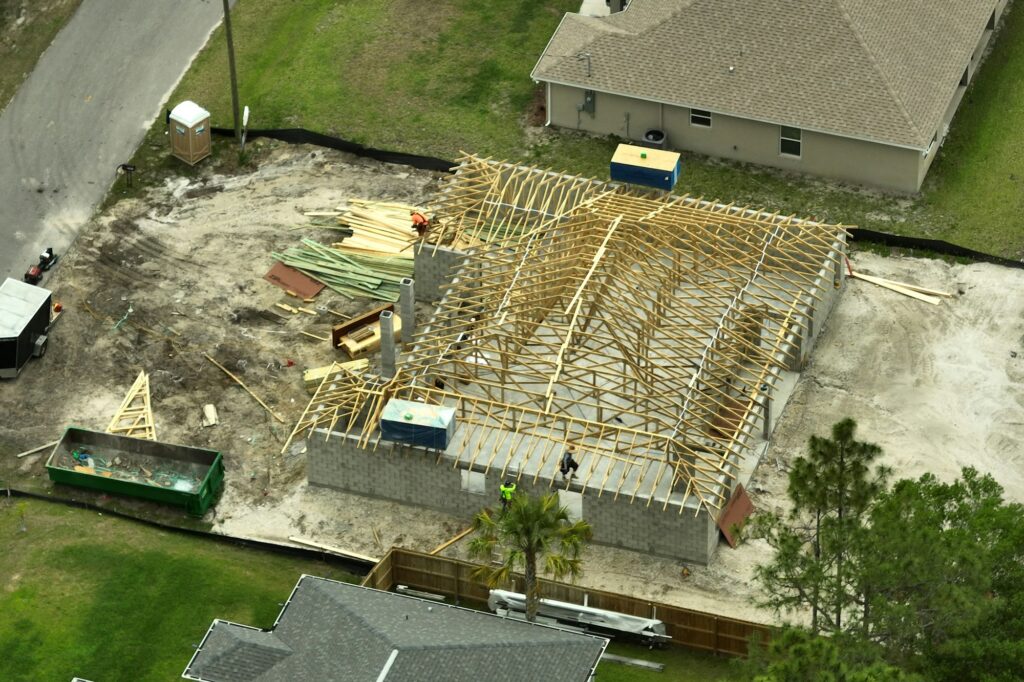 Aerial view of suburban private house wit wooden roof frame under construction in Florida