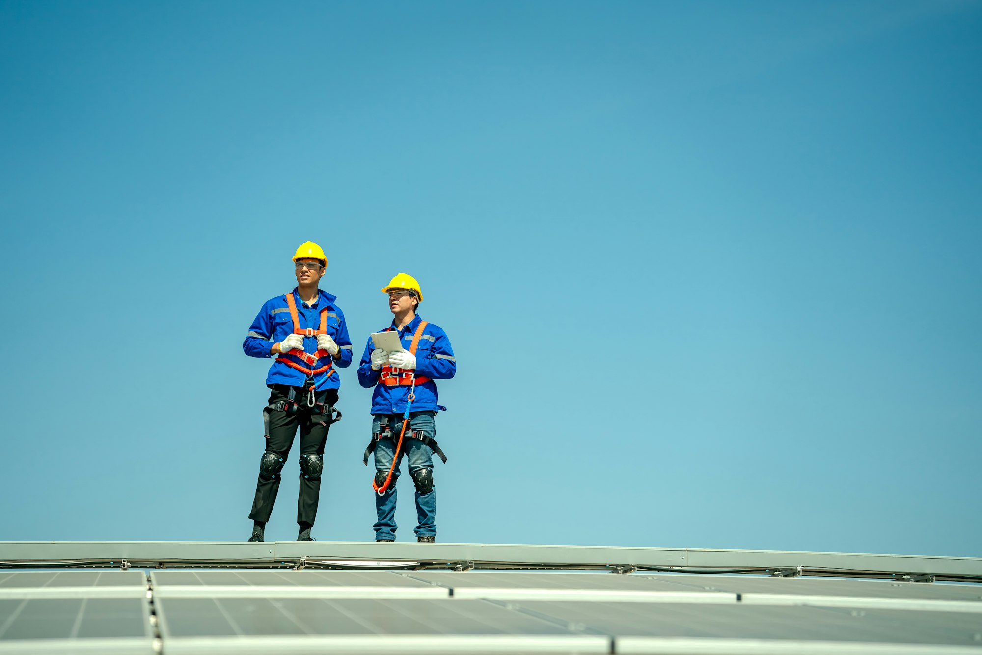 Engineer service check installation solar cell on the roof of factory.