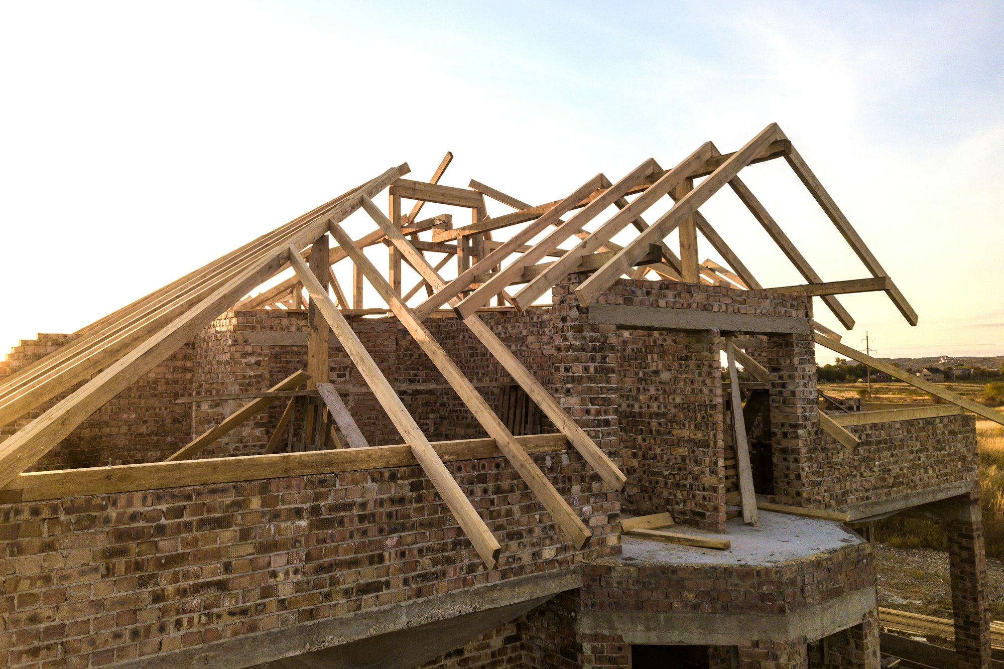 Private residential house with wooden roof frame structure under construction.